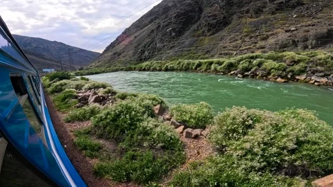 A train passes a river in the mountains Video stock 282356690