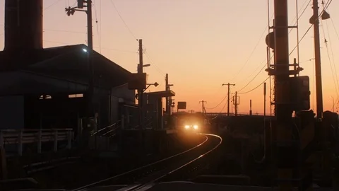 A Train Passes By a Station Under Sunset Stock Footage 123262679