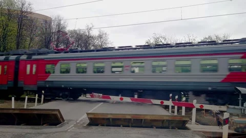 The train passes through the crossing, view from the road Stock Footage 153801433