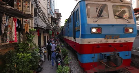 Train passes through Hanoi Train Road, just inches away from visitors' feet Stock Footage 246873356