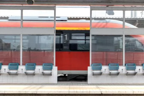 The train passes through the station with platforms. Stock Photos