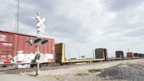 A train passes at a train crossing in the desert Stock Footage 134356214