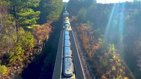 A train passes under a bridge on a bright morning in Georgia Pan up Stock Footage 147096774