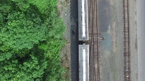The train passes under the camera as the drone flies forward and the train ends Stock Footage 71274872