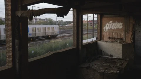 Train Passing by Abandoned Building Stock Footage 121289500