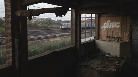 Train Passing by Abandoned Building Stock Footage 121289517
