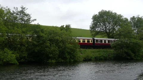 Train passing besides River Dart Stock Footage 76530261