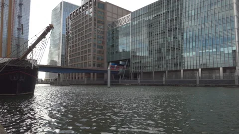 A train passing on a bridge over a river in a financial district. Stock Footage 108749816