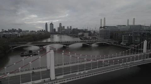 Train passing bridge over Thames river at Battersea Power Station Stock Footage 167869518