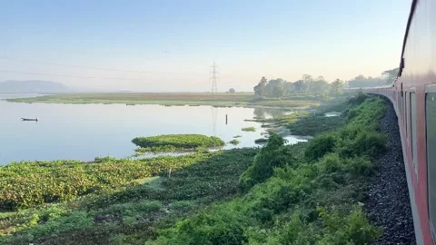 The train is passing by a large lake. Stock Footage 323355646