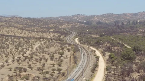 TRAIN PASSING BY IN THE MIDDLE OF THE VALLEY WITH MOUNTAINS AND TREES AROUND 4k Stock Footage 101244282
