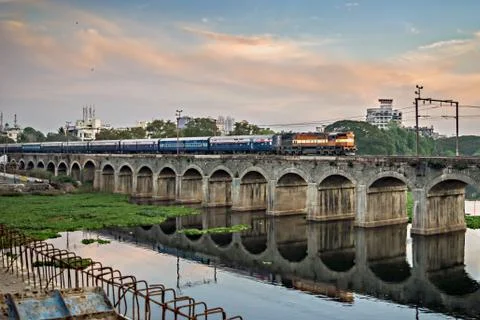 Train passing over an old bridge named Sangam bridge, with nice reflection in Stock Photos