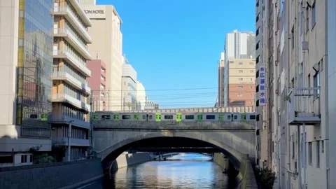 A train passing a railroad bridge over the river in Japan. Stock Footage 295191776