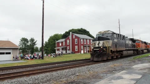 Train Passing by a Red House in a Small Town Location on a Cloudy Day Stock Footage 340342457