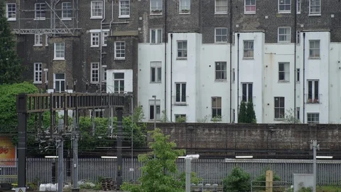 Train passing residential blocks of flats London Stock Footage 93210156