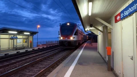 Train passing St-Saphorin station at dusk, Lake Geneva Switzerland 库存影片 333084275