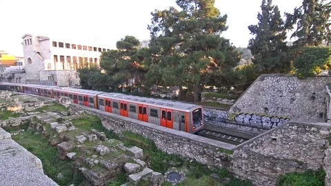 Train passing from Thisio Athens Greece and the ancient Stoa of Attalos behind Video stock 72751874