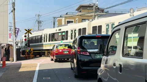 Train Passing Through a Busy Railway Crossing in Kyoto Japan Stock Footage 332830551