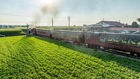 Train Passing Through Fields Near a Station in Rural America During the Aft.. Stock Photos