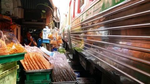 The train is passing through the Maeklong Railway market. 動画素材 119617673