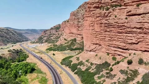 Train Passing Through Mountainous Railroad with Rocky Landscape Stock Footage 285158745