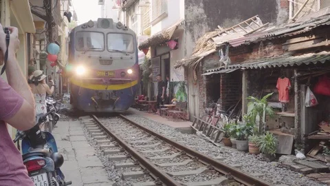 Train passing through narrow street of the Hanoi Old Quarter Stock Footage 108264408
