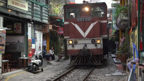 Train passing through a narrow street of the Hanoi Old Quarter, Vietnam Stock Footage 139681276