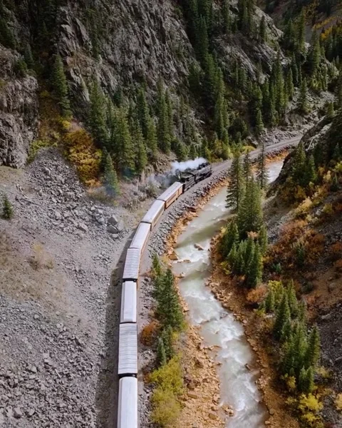 Train passing through the river in the mountains Stock Footage 269810107