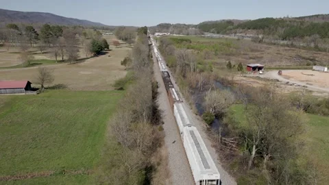 Train passing through a rural landscape Stock Footage 271185788