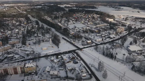 Train passing through a small town covered in snow at winter aerial timelapse Stock Footage 257792085