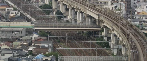Train passing through train station on tracks, surrounded with poles, Tokyo Stock Footage 136126658