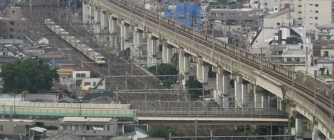 Train passing through train station on tracks, surrounded with poles, Tokyo Stock Footage 136127876