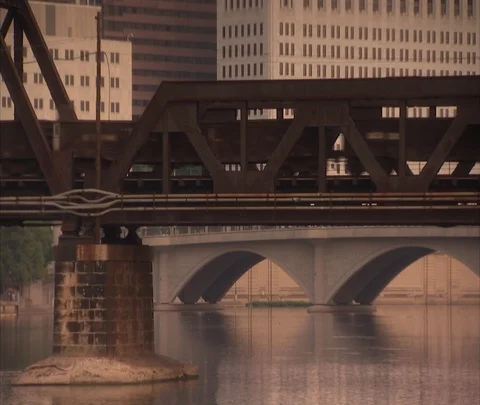 Train passing through on trestle bridge, zoom out to Columbus, OH skyline Stock Footage 86695540