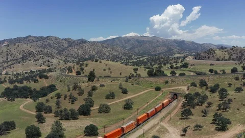 Train passing through tunnel at Tehachapi Loop, Aerial Rising Shot Stock Footage 112145871
