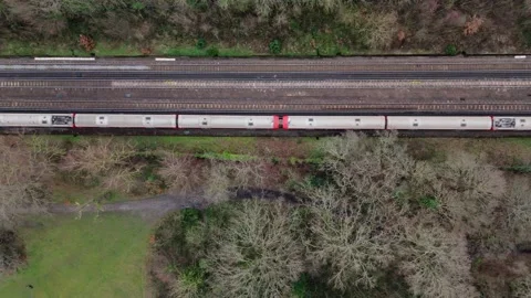 Train passing on tracks in park with wintered trees. Top down shot Video stock 264343016