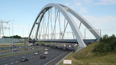 Train passing on the train bridge crossing Commuters in cars driving on highway Stock Footage 112034549