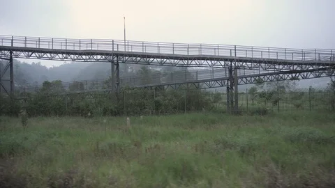 Train passing under metalic bridge for pedestrians. Stock Footage 107791883