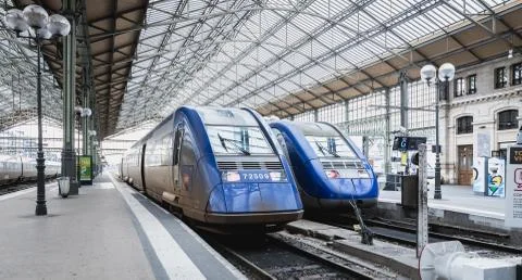 Train at platform where people walk inside Tours train station Stock Photos
