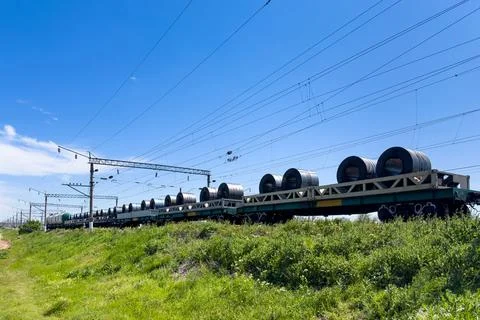 Train platforms loaded with sheet metal in large rolls. Stock Photos