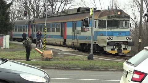 Train in poor technical condition and old, passes at the crossing, people Stock Footage 85398809