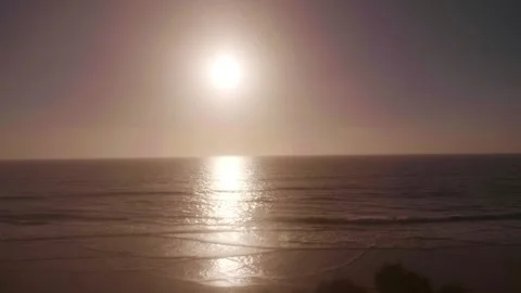 Train POV on sunset over the ocean, capturing the sun's reflection on the w.. Stock Footage 282029159