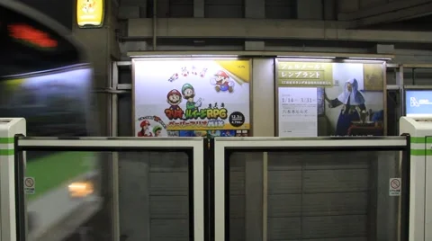 Train Pulling into station automatic barriers Tokyo Video stock 58960835