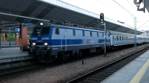 Train pulling into train station next to traffic light and people Stock Footage 245098088