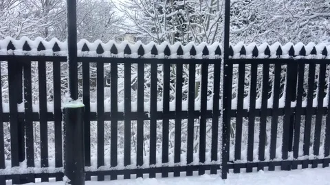 Train pulls out of a Snow concealed Platform and passes under a bridge Stock-Footage 84676672