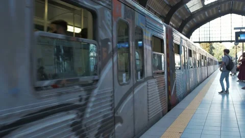 Train pulls into Piraeus Metro Station while commuters wait to board Stock Footage 223520448