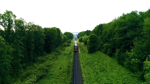 Train on railroad track. forest on both sides. shooting drone Stock Footage 94523507