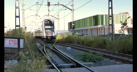 Train on rails stopping at outdoor platform seen from the ground Stock Footage 216545948