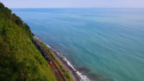 Train on railway, green mountain and blue sea at summer in Sochi, Russia, slow Stock Footage 276362658
