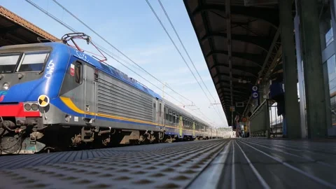 A Train at a Railway Station Pulls Away from the Platform With Few People Stock Footage 245428400
