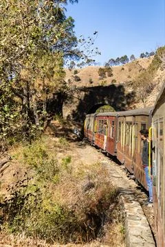 Train ride through hillside with forest trees and tunnel entrance 스톡 사진